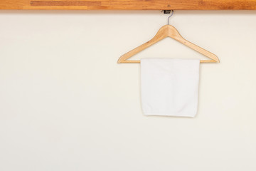 Wooden cloth hanger on rail with cotton towel in wooden open wardrobe 
