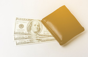 Wallet and 100 US Dollars With an orange light background. Gift money. buy goods.
