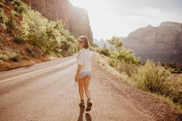 Femme marchant au bord de la route à Zion National Park