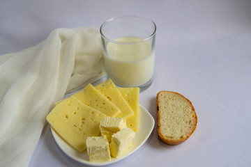 Milk, cheese, butter, white bread on a light background. Good morning, Breakfast, simple food.