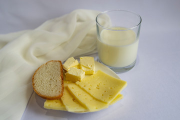 Milk, cheese, butter, white bread on a light background. Good morning, Breakfast, simple food.