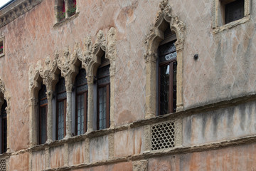 Fototapeta na wymiar Old mullioned windows in Venetian style tuff in Padua, Italy.