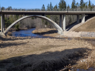 landscape with arched bridge over the river, early spring