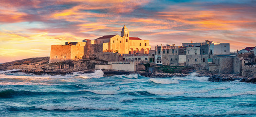 Naklejka premium Panoramic morning cityscape of Vieste - coastal town in Gargano National Park with Church of San Francesco, Italy, Europe. Spectacular spring sunrise on Adriatic sea.