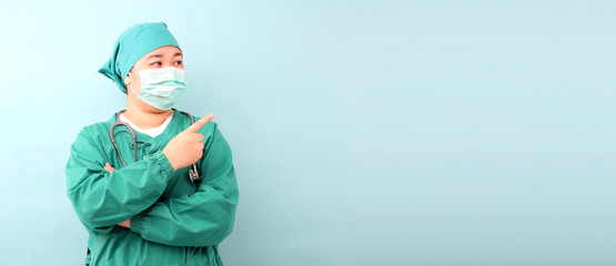 Female asia surgeon,surgeon showing stethoscope wearing surgeon mask, on a blue background in studio With copy space.
