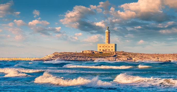 Stormy morning view of lighthouse in Vieste town. Fantastic spring sunrise on Adriatic sea, Gargano National Park, Apulia region, Italy, Europe. Traveling concept background..