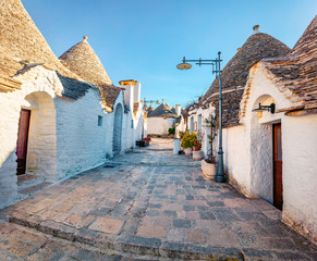 Stunning morning view of strret with trullo  -  traditional Apulian dry stone hut with a conical...