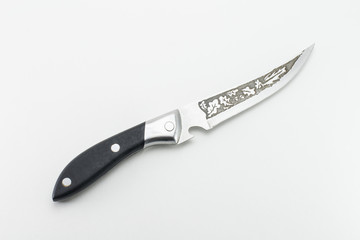 Kitchen knife with a black hilt. Patterns in the form of oak leaves on a blade.