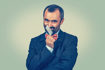 man smiling scratching, touching his nose with an ace card
