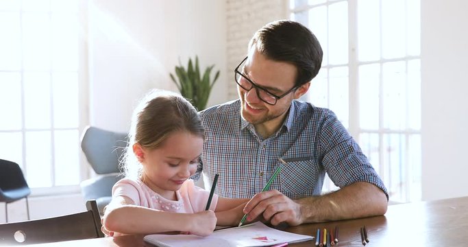 Creative cute daughter and happy father drawing giving high five