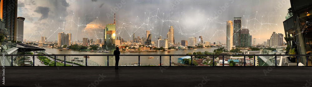 Poster businessman standing using smart phone in modern space watching city night view.business wireless ne