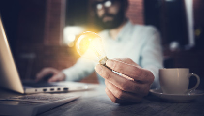 businessman hand light bulb with computer on desk