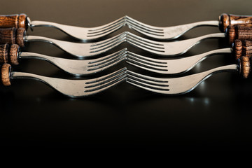 set a set of forks with wooden handles on a black background
