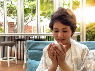 Charming happy brunette woman drinking coffee at coffee shop.