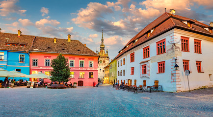 Picturesque evening view of famous medieval fortified city and the Clock Tower built by Saxons. Splendid  summer cityscape of Sighisoara, Transylvania, Romania, Europe. Traveling concept background. - obrazy, fototapety, plakaty