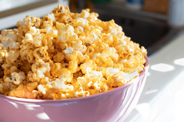 Butter popcorn in pink big bowl. Preparation for new year party, cerebrate occasion. Non-healthy food concept.