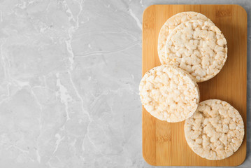 Crunchy rice cakes on grey marble table, top view. Space for text