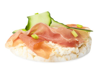 Puffed rice cake with prosciutto and cucumber isolated on white
