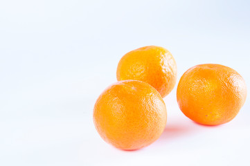 Three juicy tangerines on a white background.
