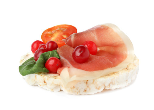 Puffed rice cake with prosciutto, berries and tomato isolated on white