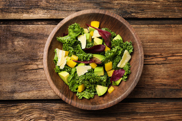 Delicious kale salad served on wooden table, top view