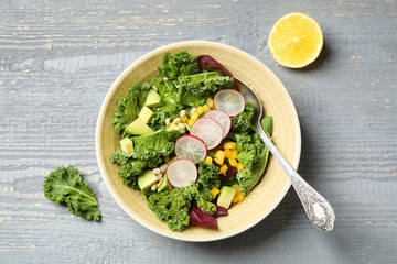 Delicious kale salad served on grey wooden table, flat lay