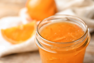 Homemade delicious orange jam on table, closeup view
