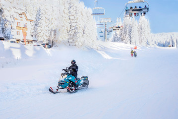 Man driving sports snowmobile in mountain ski resort
