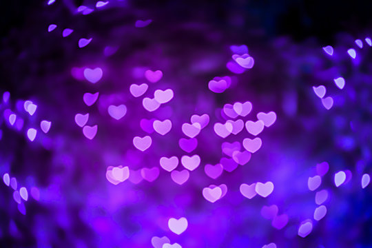 Abstract beautiful blurred violet-purple-lilac and pink colored of swirling heart shaped bokeh from ornamental lights flickering in the park. Background for Valentine’s day or Love or Romance concept.