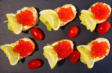 Red caviar sandwich with lemons and tomatoes