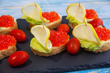 Red caviar sandwich with lemons and tomatoes