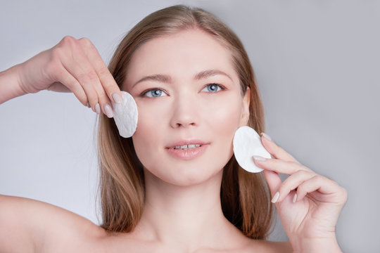 Healthy fresh girl removing makeup from her face with cotton pad. woman with a sponge wihte background cotton pad problem skin