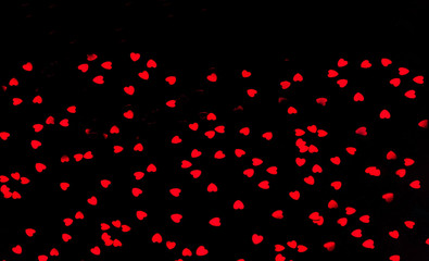Festive black background from decorative red hearts.Holiday background for packaging and projects.Copy space