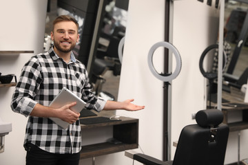 Fototapeta premium Young business owner with tablet in barber shop