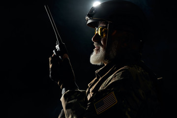 Military officer holding radio station.