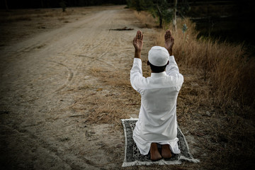 Silhouette Young asian muslim man praying on sunset,Ramadan festival concept