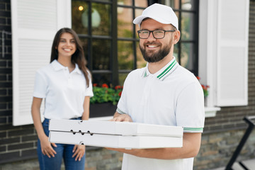 Obraz premium Smiling deliveryboy holding boxes of pizza.