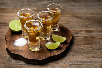 Mexican Tequila shots, lime and salt on wooden table