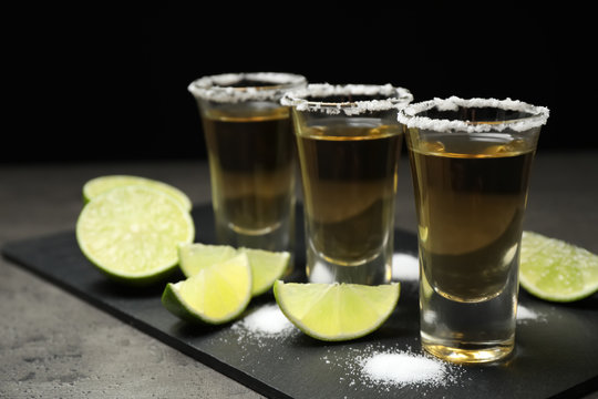 Mexican Tequila shots with salt and lime on grey table
