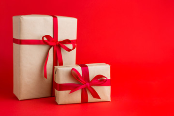 Two Brown gift boxes with red ribbons on Red background. Gift for Christmas, Valentine day or a birthday.