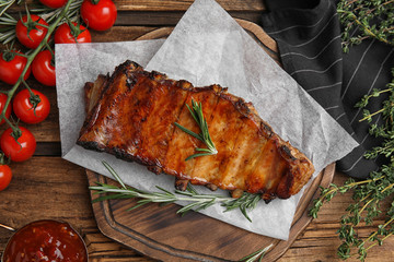 Tasty grilled ribs on wooden table, flat lay