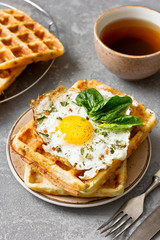 Fried egg on cheese viennese waffles with basil and spices