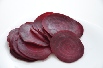 beautifully sliced beetroot stacked on top of each other, round slices of raw and healthy greenery full of vitamins and minerals, vegan and vegetarian healthy food, white background