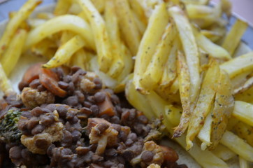 baked potatoes cut into French fries with lentils, homemade vegan food, healthy food cooked at home