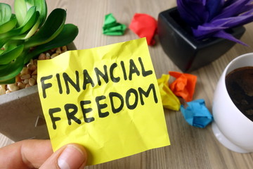 Text financial freedom handwritten on sticky note