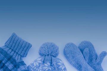 Sweater hat and gloves on light background with copy space winter concept creative flat lay color of the year classic blue toned