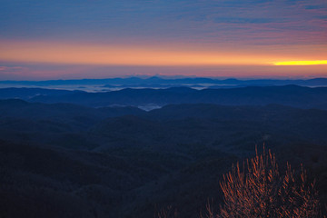 Colorful sunrise over layered mountains after ice storm in Blowing Rock, North Carolina.
