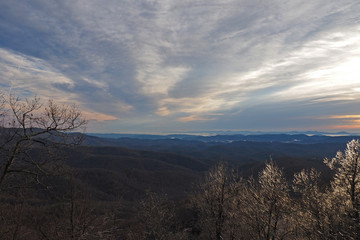 Colorful sunrise over layered mountains after ice storm in Blowing Rock, North Carolina.