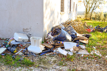Garbage dump on the grass near the forest, ecological disaster concept, polluting nature. Illegal...
