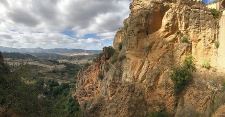 Bridge in Ronda famous and romantic Andalusia Spain. Photo from the viewing point under the bridge.  You can see the rocky cliffs of both sides of the bridge